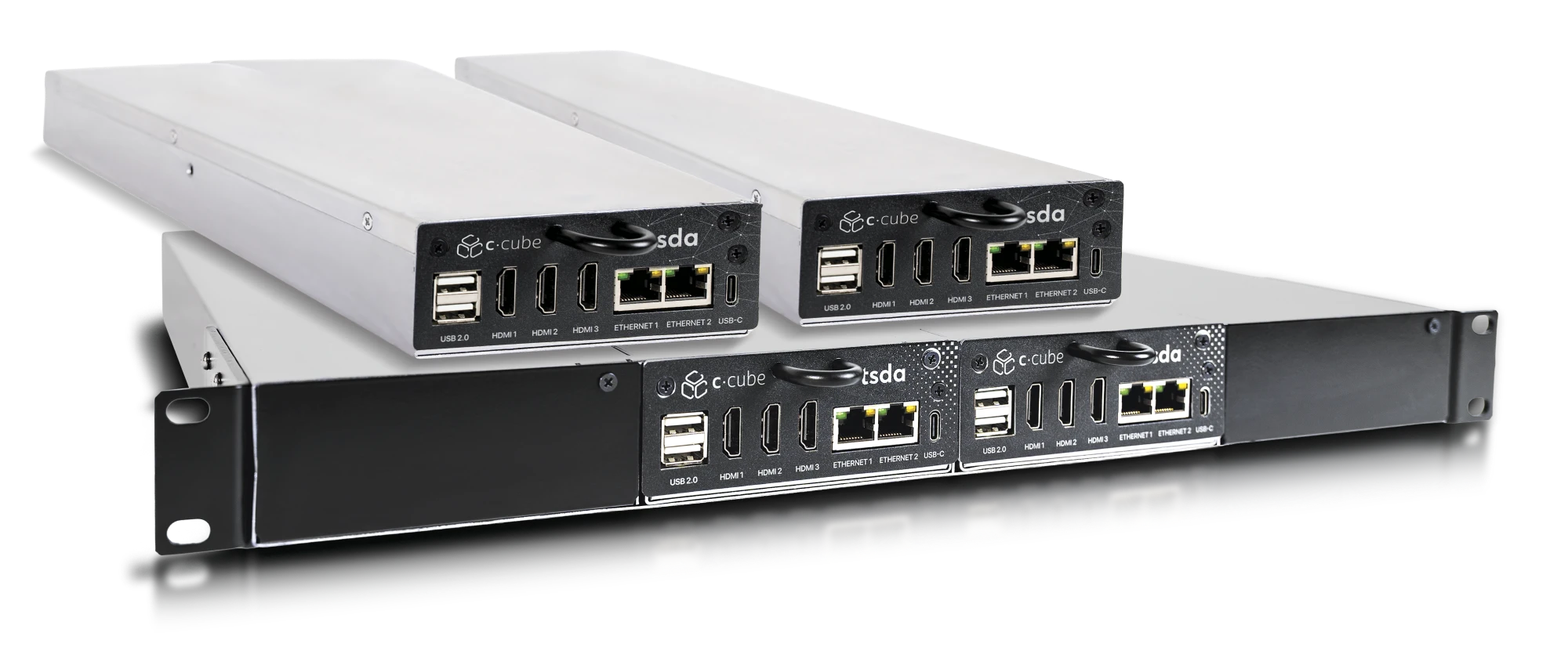 Três unidades C·CUBE da TSDA: dois gabinetes compactos prateados e um módulo duplo em Rack 19 polegadas preto, com portas USB, HDMI e Ethernet no painel frontal.